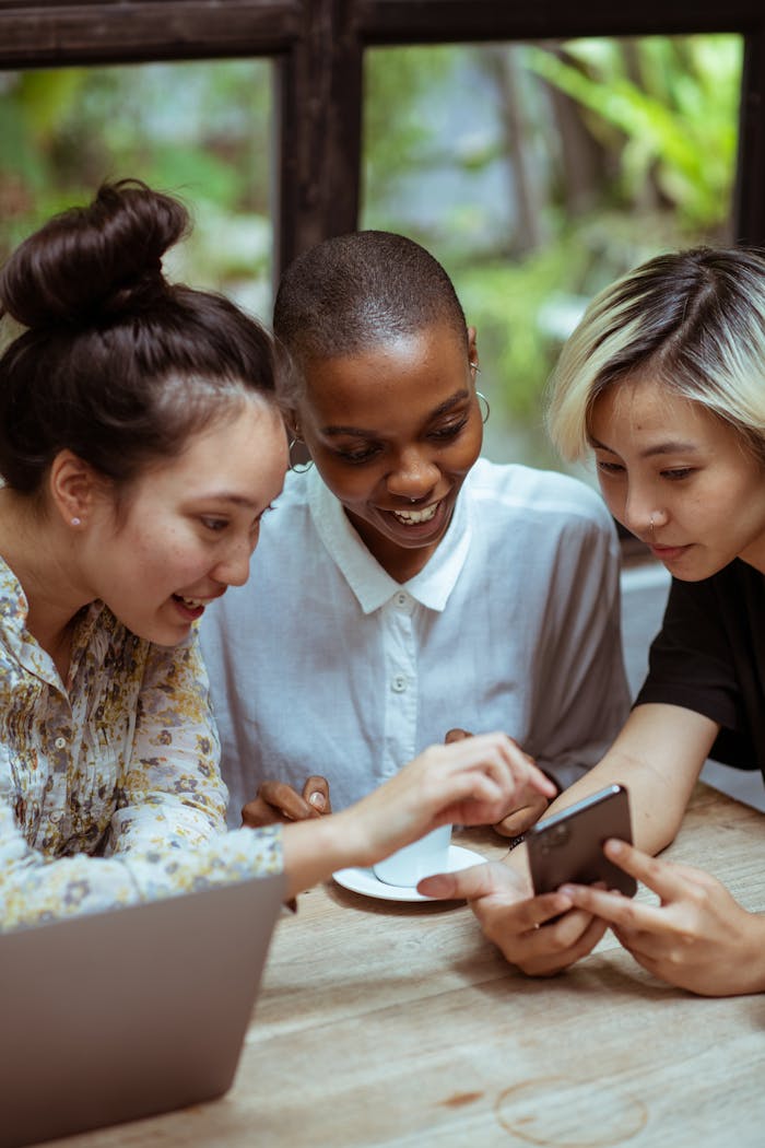 Cheerful multiethnic women browsing smartphone